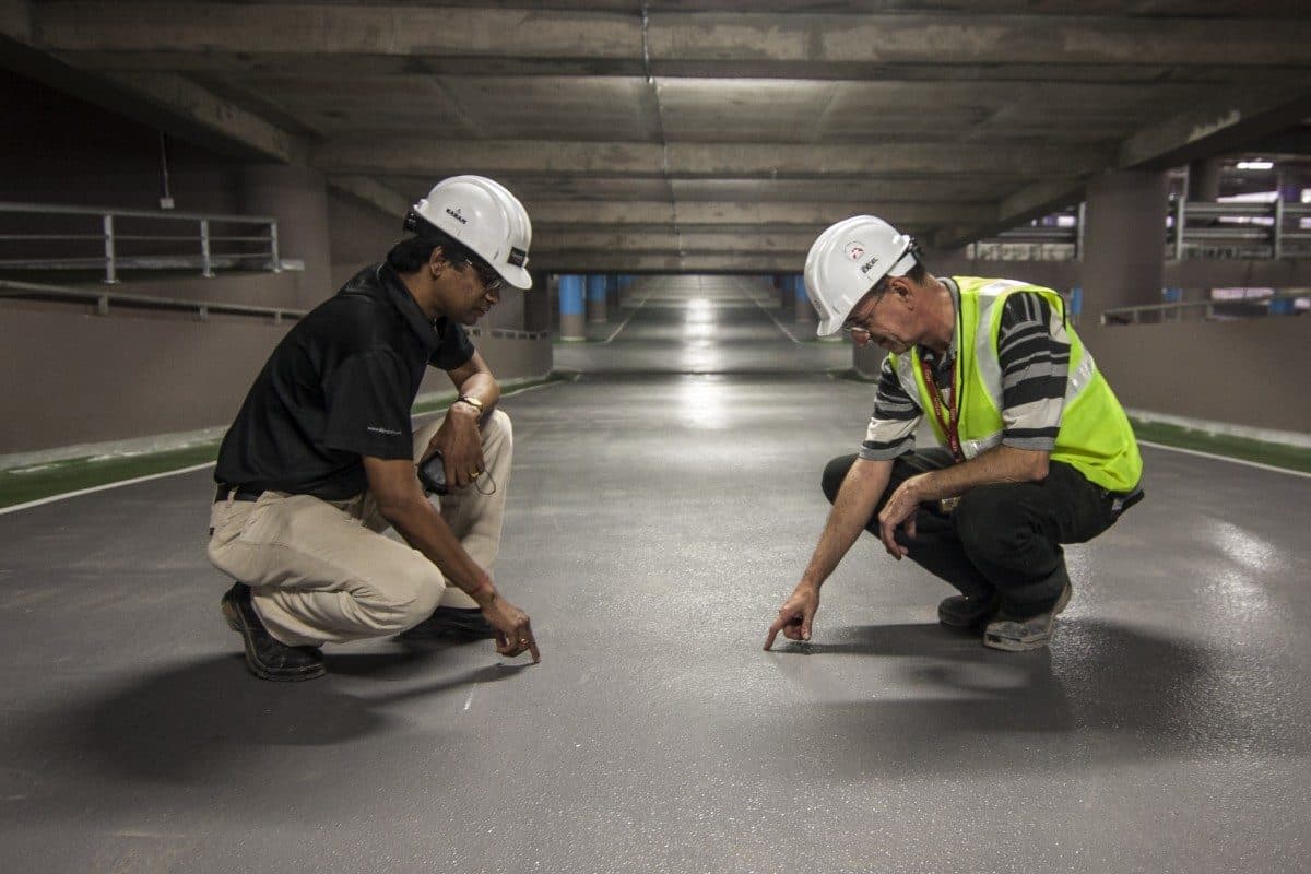 Två hantverkare går igenom ett betonggolv före rivningsstart